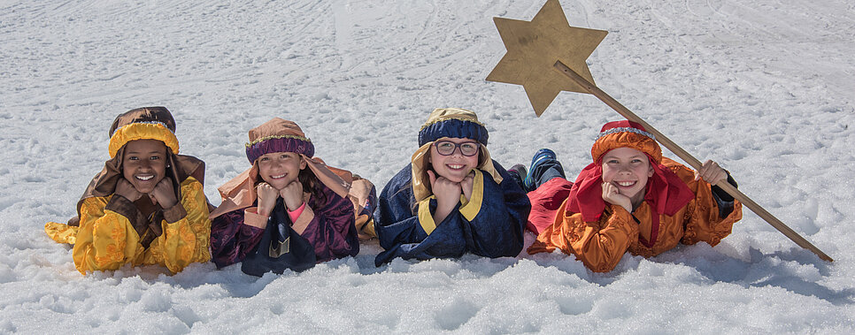 Sternsinger liegend im Schnee