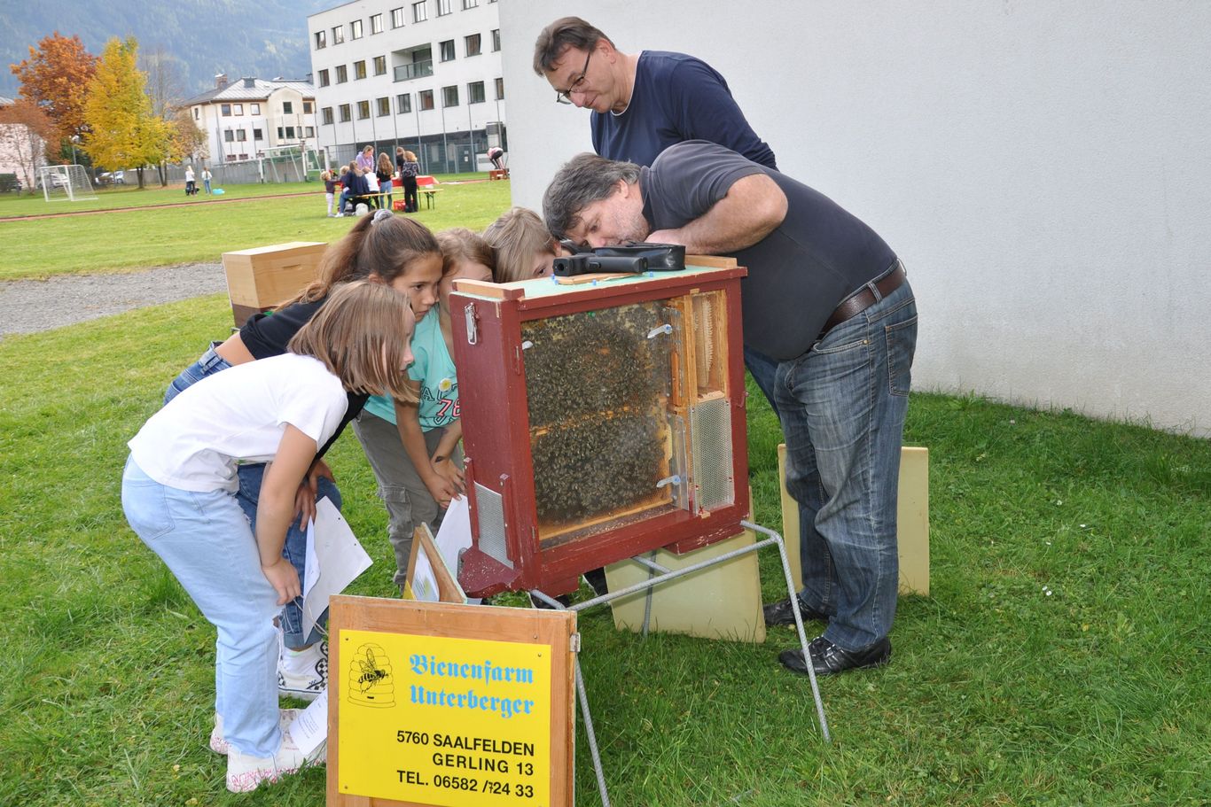 Ein Imker erklärt Kindern einen Bienenstock